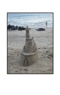 sandcastle with little girl in background
